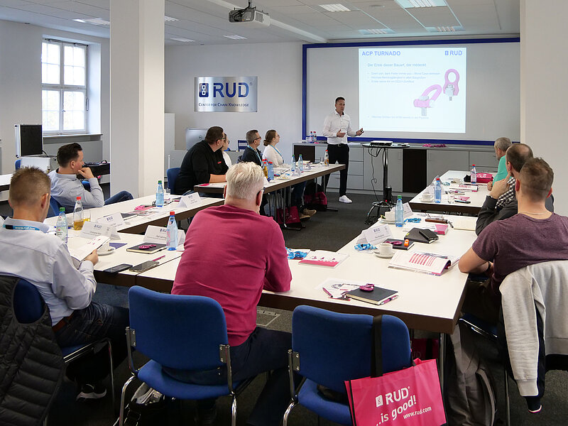 Präsenzschulung bei RUD: Teilnehmer hören einem Vortrag über den Anschlagpunkt ACP-TURNADO zu.