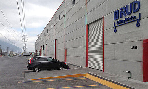 RUD SpanSet Mexico SA de CV Standort mit grauer Industriehalle, Firmenlogo an der Fassade und Parkflächen davor.