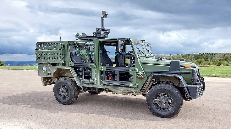 Militärisches Geländefahrzeug mit offener Seitenkonstruktion, ausgestattet mit RUD Zurrpunkten für den sicheren Transport.