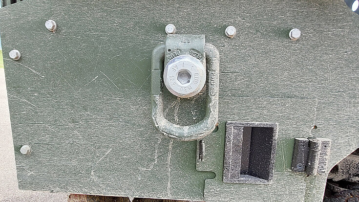 Detailaufnahme eines befestigten RUD Zurrpunkts an der Fahrzeugseite für militärische Transportanwendungen.