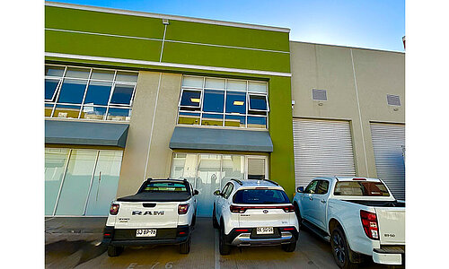 RUD SpanSet Chile Standort mit silberner Wellblechhalle, großem RUD Logo an der Fassade und geöffneter Eingangshalle.