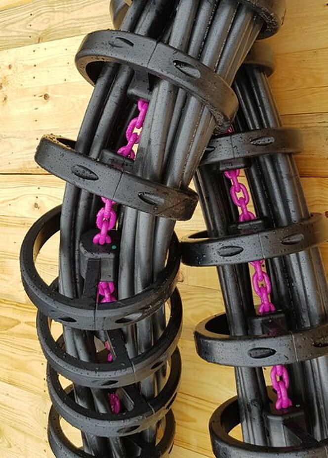 Detailansicht einer Energieführungskette mit integrierter RUD ICE-Kette und mehreren schweren Kabeln.