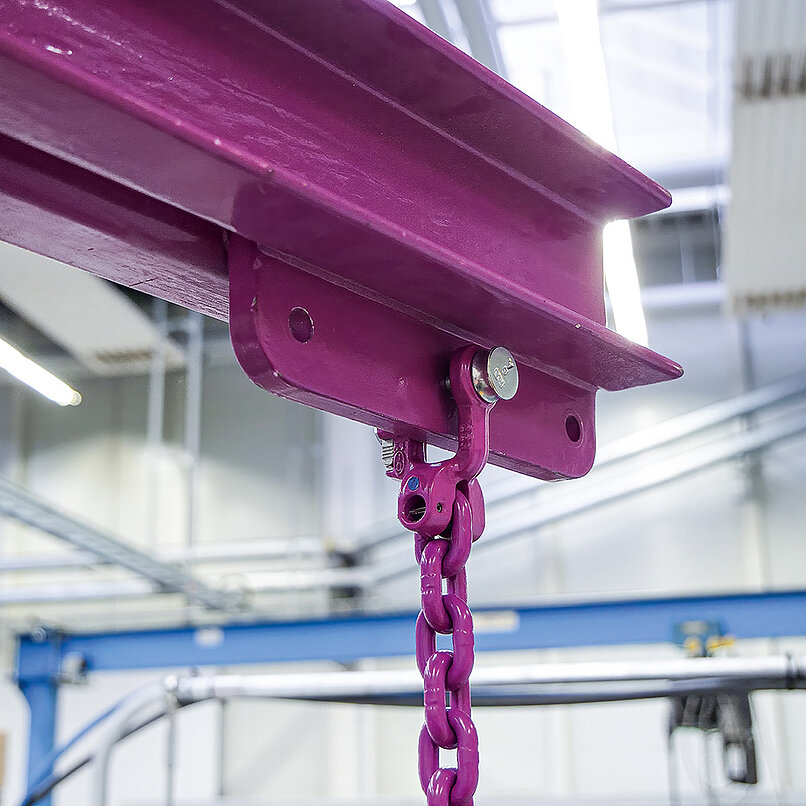 nschlagkette mit pinkem Verbindungselement an einem Träger in einer Industriehalle befestigt.