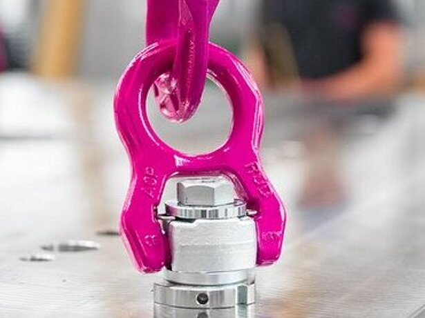 Ein drehbarer RUD Anschlagpunkt ACP-TURNADO ist mit einer ICE-Kette verbunden und an einem glänzenden Metallbauteil befestigt.