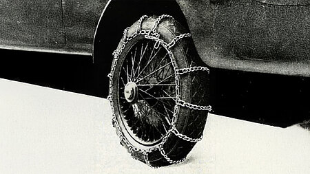 Historisches Foto eines Fahrzeugs mit den ersten Gleitschutzketten, 1910.