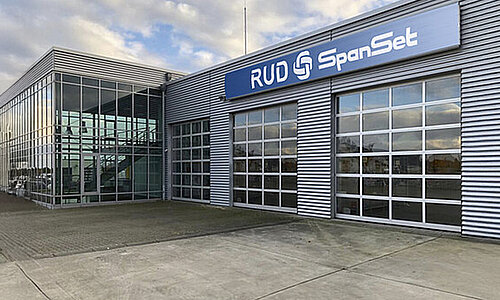 Moderne Firmenzentrale der RUD SpanSet GmbH mit Glasfassade und großem Logo an der Front.