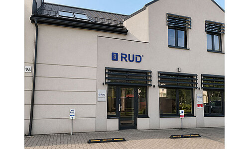 Bürogebäude von RUD Lifting Polska Sp. z o.o. mit RUD-Logo am Eingang.
