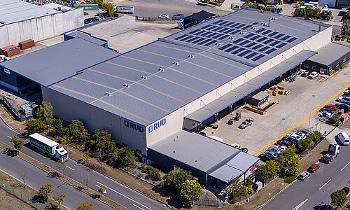 RUD Chains Pty Ltd Standort in Australien, modernes Industriegebäude mit großem RUD Logo, mehreren Ladebuchten und angrenzendem Parkplatz.