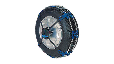 RUD Centrax Schneekette mit blauen Halterungen und silbernen Kettengliedern, montiert auf einem Autoreifen, freigestellt vor weißem Hintergrund.