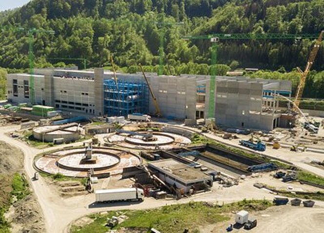 Großbaustelle der Papierfabrik Palm in Aalen mit Stahlbetonbau, Krananlagen und runden Fundamentanlagen im Vordergrund.