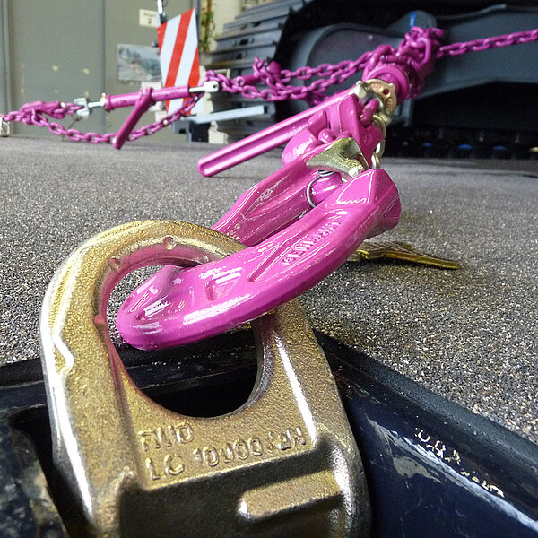 RUD Optilash Click mit pinker Kette zur Ladungssicherung an einem Zurrpunkt befestigt.     