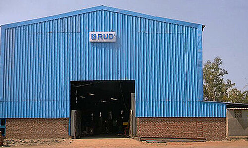 Außenansicht einer großen blauen Halle des RUD Standorts India Chain Pvt. Ltd.