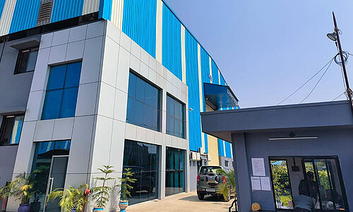 Außenansicht einer großen blauen Halle des RUD Standorts India Chain Pvt. Ltd.