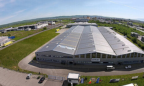 Luftaufnahme des RUD Standorts Florian Rieger SRL mit großem Industriegebäude und Firmenlogo.