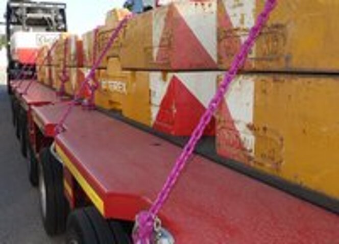 Mit RUD-Zurrketten gesicherte Schwerlastgewichte auf einem Goldhofer-Tieflader.