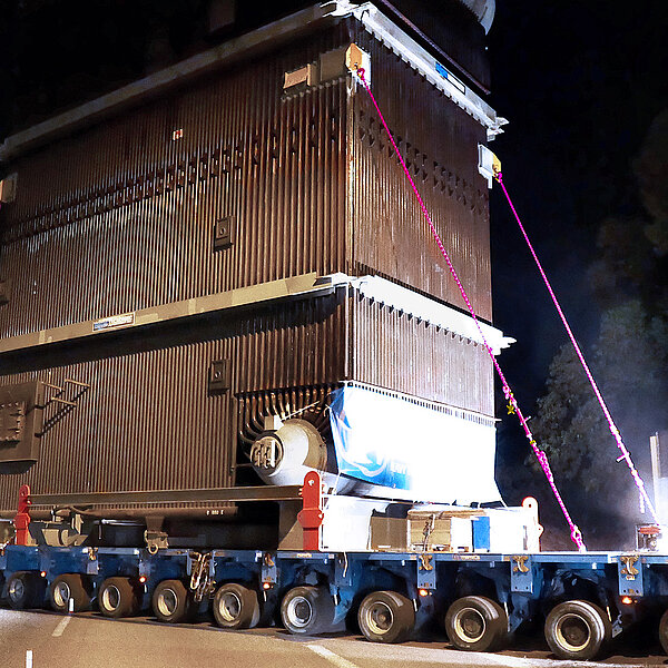 Schwertransport bei Nacht: Sicherung eines großen Transformators mit RUD Zurrketten für maximale Transportsicherheit.