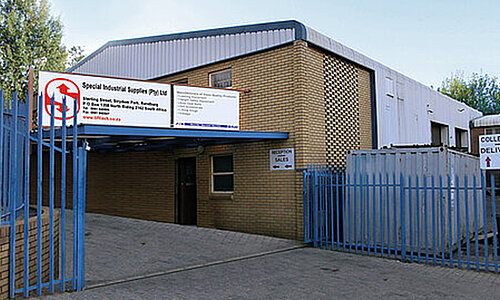 Außenansicht des Standorts Special Industrial Supplies Ltd. mit Backsteingebäude und blauen Toren.