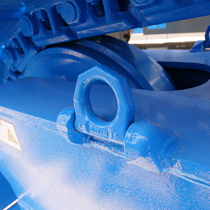 Blau lackierter RUD-Zurrpunkt auf einem massiven Maschinenbauteil. Der angeschweißte Zurrpunkt befindet sich vor einem großen Zahnradsegment und ist Teil einer robusten technischen Konstruktion.