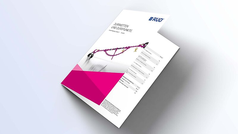 Produktkatalog für Zurrketten und Zurrpunkte von RUD, auf einer Ecke liegend, mit pinkem Designelement.