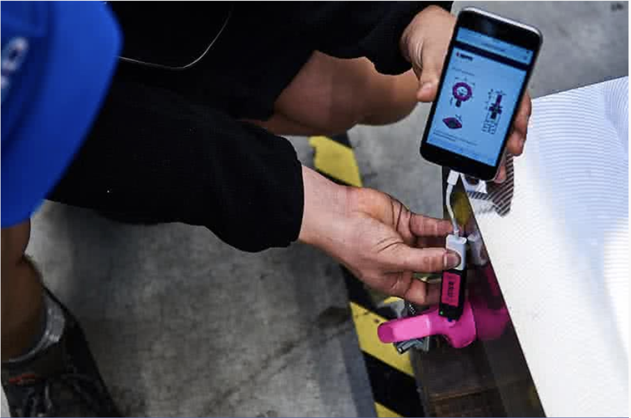 Digitale Prüfung eines RUD-Hebemittels per Smartphone in Kombination mit einem pinken RFID-Tag im Industriebereich.