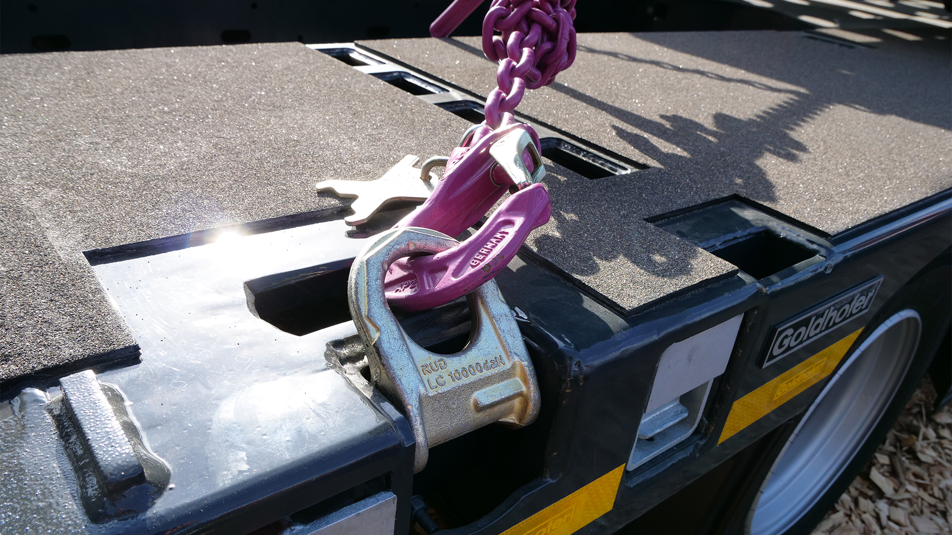 RUD Zurrpunkt mit pinker Zurrkette an einem Goldhofer Tieflader – Detailaufnahme der Ladungssicherungskomponente.