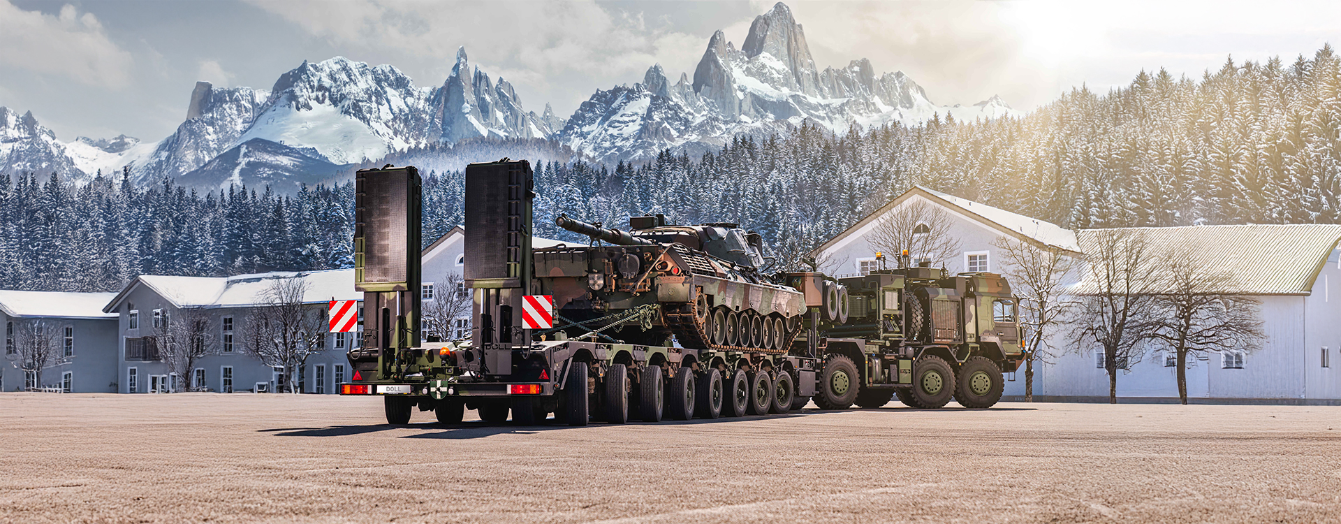 Schwerlasttransport mit Panzer auf Militärfahrzeug vor verschneiter Bergkulisse – Einsatz modernster RUD-Technologie für Defence-Lösungen.